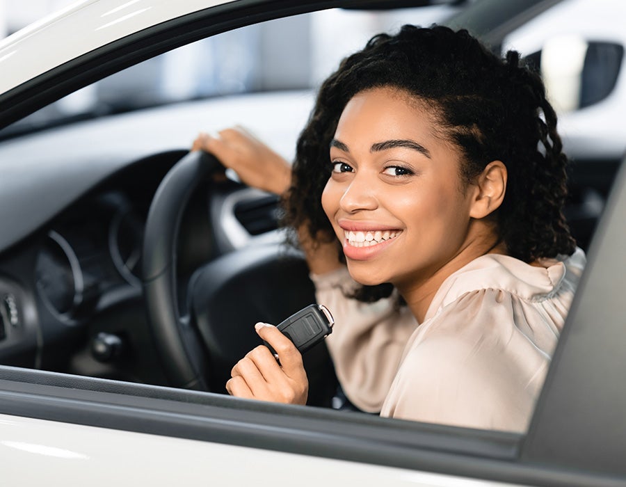 woman smiling in drivers seat of car